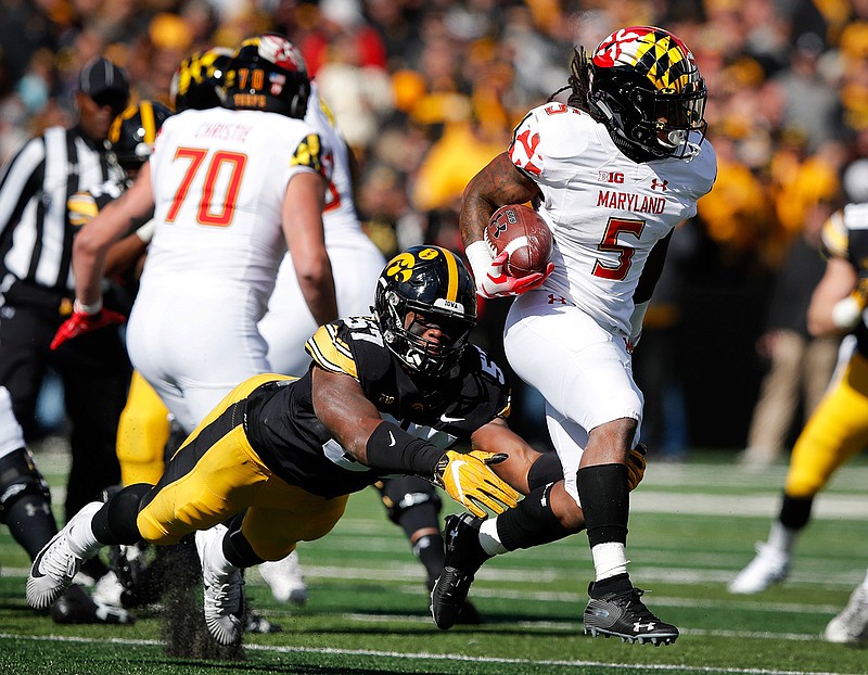  In this Saturday, Oct. 20, 2018, file photo, Maryland running back Anthony McFarland (5) is tackled by Iowa defensive end Chauncey Golston (57) during the second half of an NCAA college football game, in Iowa City, Iowa. McFarland started only five games as a freshman, yet still managed to top the 1,000-yard mark. He raised eyebrows around the Big Ten after running for 298 yards against Ohio State. Now he's poised to become one of the league's dominant backs. (AP Photo/Charlie Neibergall, File)