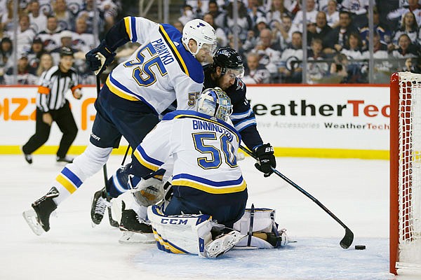 Kevin Hayes of the Jets attempts to tip the loose puck into the net behind Blues teammates Colton Parayko and goaltender Jordan Binnington during the second period of Thursday night's Game 5 of an NHL first-round playoff series in Winnipeg, Manitoba.