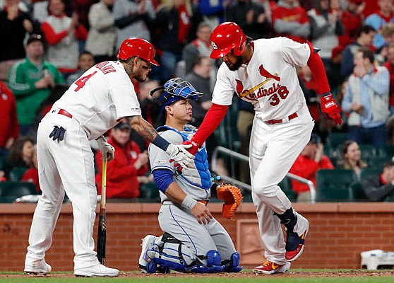 Jose Martinez is congratulated by Cardinals teammate Yadier Molina after hitting a solo home run as Mets catcher Wilson Ramos kneels at the plate during the fourth inning of Friday night's game at Busch Stadium.