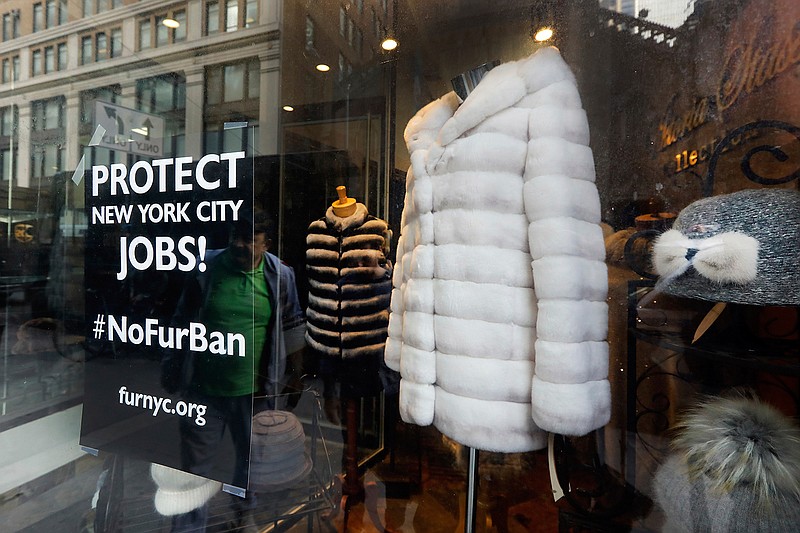 This April 10, 2019, photo shows a sign by furnyc.org in the window of Victoria Stass Collection in New York's fur district. The fur trade is considered so important to New York's development that two beavers adorn the city's official seal, a reference to early Dutch and English settlers who traded in beaver pelts. (AP Photo/Richard Drew)