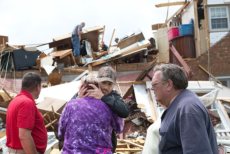 Delores Anderson, 63, center left, looks toward the wreckage of her house while comforted by friends and neighbors who came to support and help pull belongings from her home after it was destroyed by a tornado Friday, April 19, 2019, in Franklin County, Va. (Heather Rousseau/The Roanoke Times via AP)