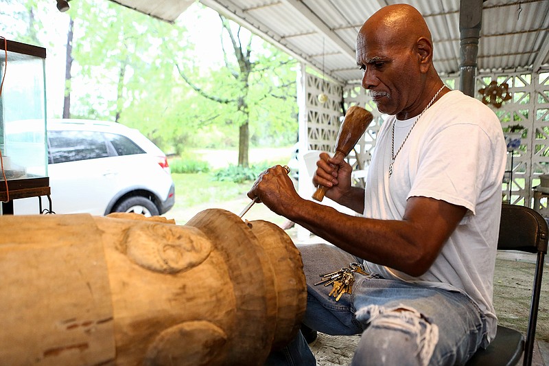 Ivory Henderson works on an African drum on his patio in Redwater, Texas. Henderson has been woodworking for 45 years and specializes in African traditional pieces.