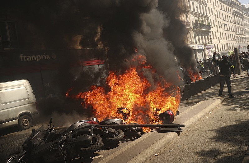 A set of motorbikes are set alight during a yellow vest demonstration in Paris, Saturday, April 20, 2019. French yellow vest protesters are marching anew to remind the government that rebuilding the fire-ravaged Notre Dame Cathedral isn't the only problem the nation needs to solve. (AP Photo/Francisco Seco)