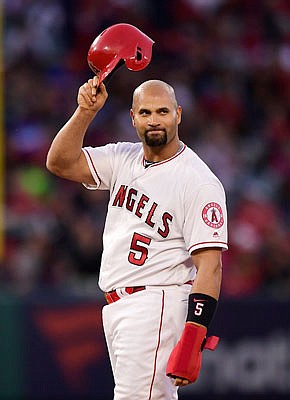 Albert Pujols of the Angels tips his helmet to fans after hitting an RBI double during the third inning of Saturday night's game against the Mariners in Anaheim, Calif.