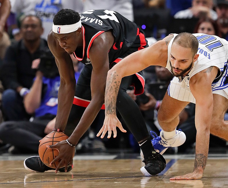 Toronto Raptors' Pascal Siakam, left, grabs the ball in front of Orlando Magic's Evan Fournier during the second half in Game 3 of a first-round NBA basketball playoff series, Friday, April 19, 2019, in Orlando, Fla. (AP Photo/John Raoux)