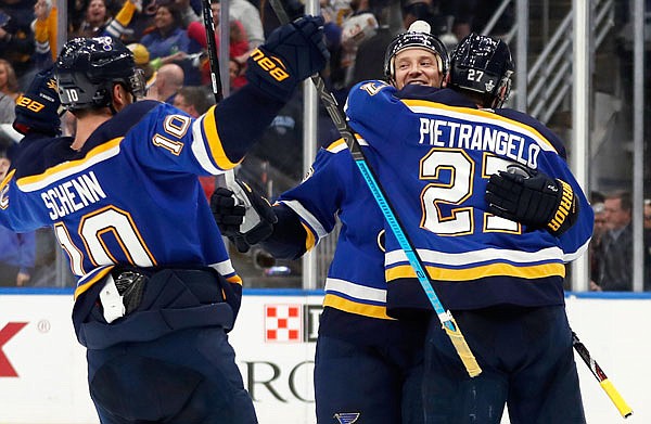 Jay Bouwmeester (center) of the Blues celebrates with teammates Brayden Schenn (left) and Alex Pietrangelo after defeating Jets on Saturday in Game 6 of a Western Conference first-round playoff series in St. Louis. The Blues won the series 4-2 to advance in the Stanley Cup playoffs.