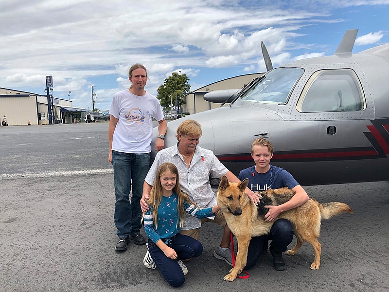 Kneeling, from left, Chloe, Doug and Chase Peterson greet their long-lost German Shepherd dog Cedar on Saturday, April 20, 2019, at Fort Lauderdale Executive Airport in Fort Lauderdale, Fla. Cedar, 2, was stolen from her home in Southwest Ranches in 2017 and located this month in Colorado. Standing is pilot Ted DuPuis.