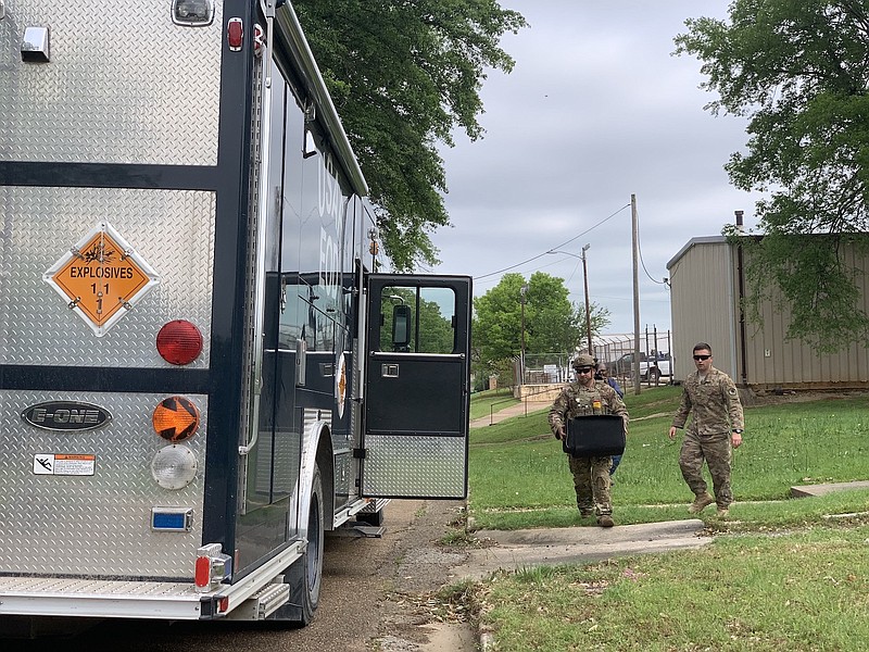 Barksdale Air Force Base's team carry a military ordnance round found from a Texarkana, Texas, yard. The round will be taken to a safe location to determine if it is a live round. If it is, it will be detonated. 