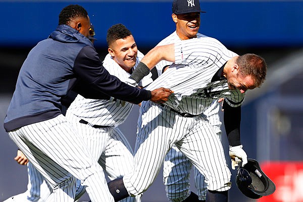 Austin Romine (right) of the Yankees is congratulated by teammates after hitting a walk-off single during the 10th inning of Sunday's game against the Royals in New York.