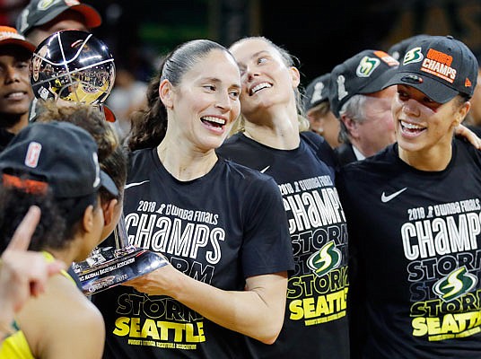 In this Sept. 18, 2018, file photo, Seattle Storm guard Sue Bird holds the championship trophy with her teammates after winning Game 3 of the WNBA Finals in Fairfax, Va.