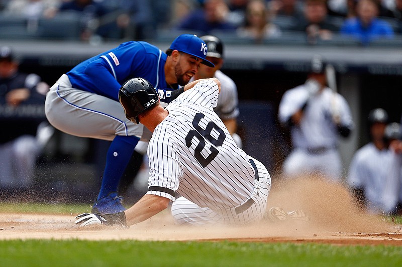  New York Yankees' DJ LeMahieu, right, scores a run ahead of a tag by Kansas City Royals pitcher Jorge Lopez, left, during the first inning of a baseball game Sunday in New York. 
