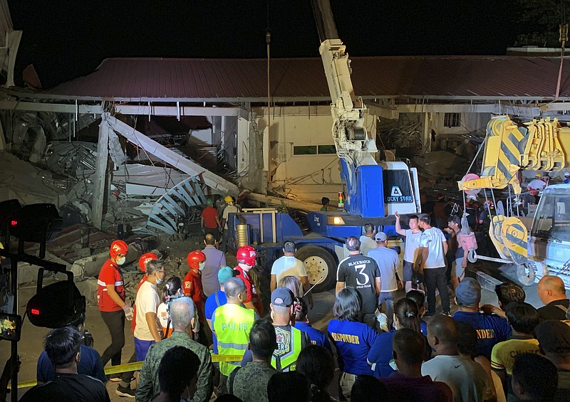 Workers continue rescue efforts on people still trapped inside a collapsed building at Porac town, Pampanga province, northern Philippines Monday, April 22, 2019. A strong 6.1 magnitude earthquake in the north Philippines on Monday trapped some people in a collapsed building, damaged an airport terminal and knocked out power in at least one province, officials said. (AP Photo/Bullit Marquez)
