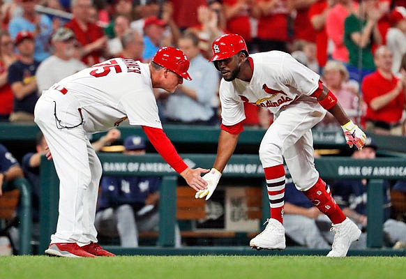 Dexter Fowler is congratulated by Cardinals third base coach Pop Warner after hitting a two-run home run during the fourth inning of Monday night's game against the Brewers at Busch Stadium.