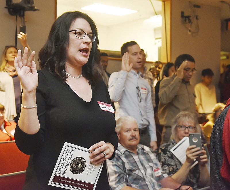 Tricia Heisler holds up her right hand and repeats the Oath of Citizenship during a naturalization ceremony Monday in the auditorium at Missouri National Guard Headquarters. Heisler, originally from Newfoundland, Canada, and moved to Jefferson City with her now-retired husband, U.S. Air Force Master Sgt. Andrew Heisler.