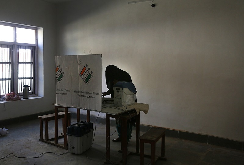 A Kashmir burqa clad woman casts her vote inside a polling station during the third phase of India's general elections, at Verinag, south of Srinagar, Indian controlled Kashmir, Tuesday, April 23, 2019. Kashmiri separatist leaders who challenge India's sovereignty over the disputed region have called for a boycott of the vote during the third phase of Indian general election. (AP Photo/Mukhtar Khan)