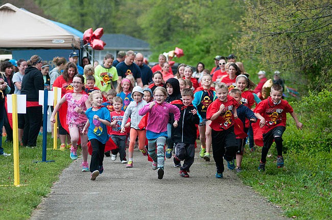 Participants during the first Superhero 5K in 2015 take off from the starting line. This annual run supports the Super Sam Foundation in its fight against childhood cancer.