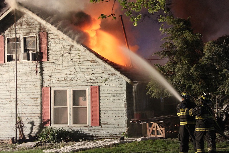 <p>Liz Morales/For the News Tribune</p><p>Fire fighters with the California Fire Department work to extinguish flames at 710 West Street April 24.</p>