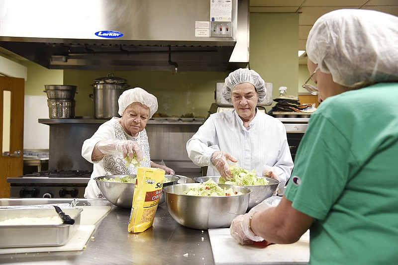 From left, volunteers Anna Orscheln, Cathy Moreland and Cheryl Buechter prepare dinner Monday at the Salvation Army Center of Hope. 