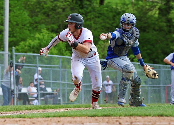 Justin Wood of the Jefferson City Jays heads toward home plate to score a run after avoiding a tag by Quincy, Ill., catcher Ryan Camerer during the fourth inning of Wednesday's game at Vivion Field.