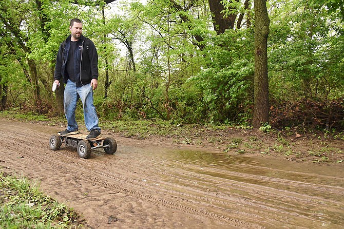 Eli Phillips is seen riding his electric skateboard through the mud left behind April 30, 2019, after flash flooding. Heavy rains throughout the day and evening caused the water to rise swiftly, leaving debris in the two ball fields on the north side of Wears Creek.