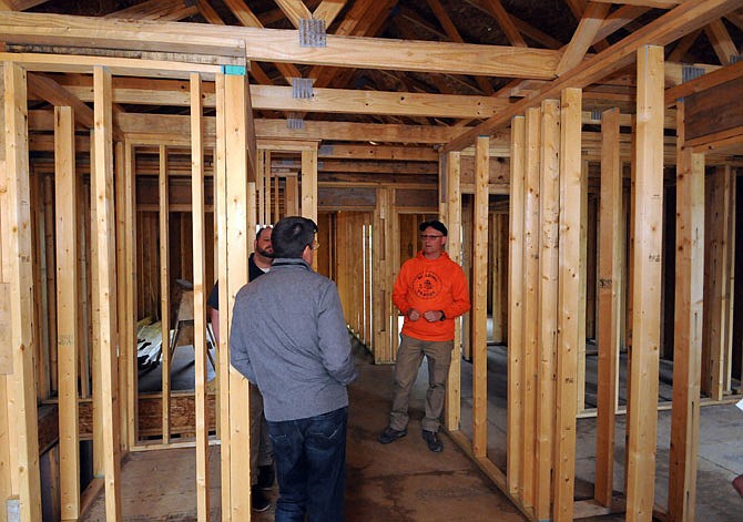 Visitors talk to instructor Bryan Wolf, right, during a Nichols Career Center building trades open house Thursday at a home under construction in the 1100 block of East Dunklin Street.