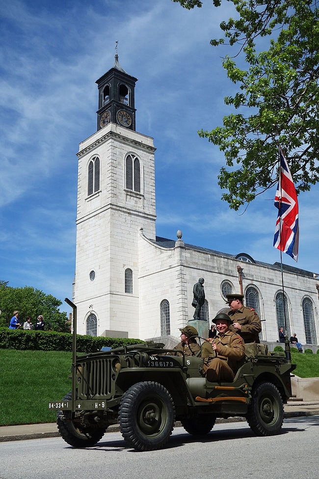 World War II re-enactors Mary Stansfield, Garry Hill and Joe Poynter (back) pass by the Church of St. Mary the Virgin, Aldermanbury during Saturday's parade. Their vehicle was one of several vintage military vehicles in the parade.
