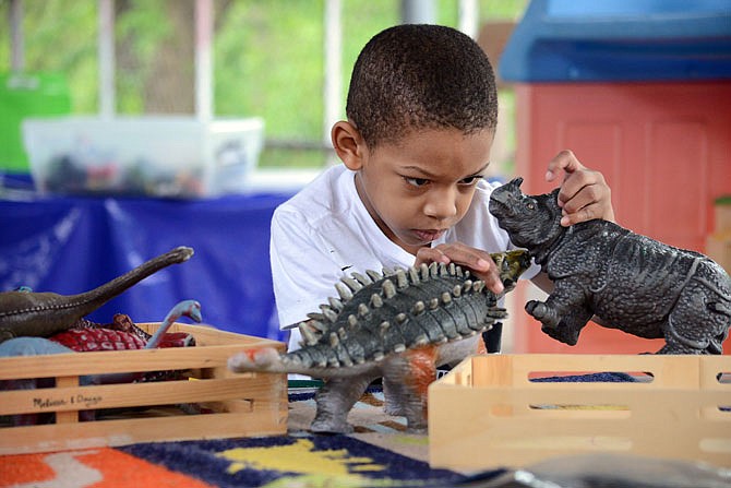 Maurice Wallace, 4, plays with dinosaurs Friday at the Apple Tree Academy. Gov. Mike Parson recently created the Child Care Working Group to look at child care in the state and provide recommendations on how best to ensure safe, quality child care that would promote his Workforce Infrastructure Initiative.
