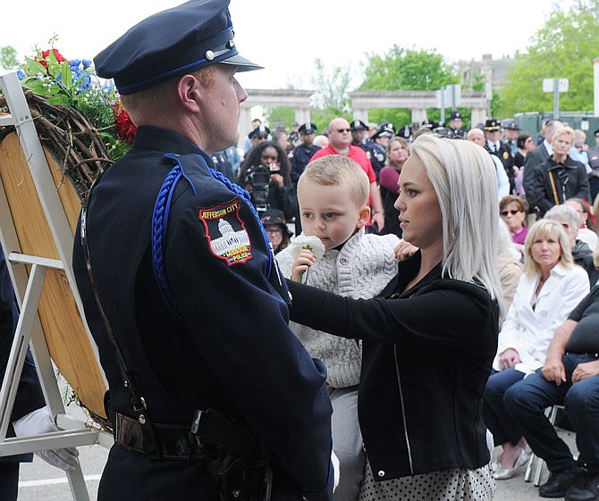 Family members of law enforcement officers who died in the line of duty place white carnations on a wreath Saturday during the 32nd annual Missouri Law Enforcement Memorial Service. 