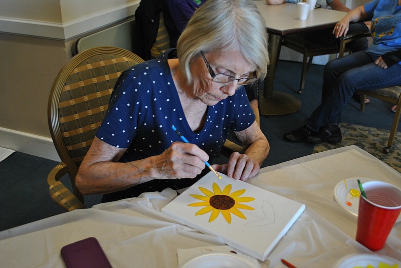 (Photo by Samantha Pogue) Linda Wohletz paints a sunflower Bittersweet Garen Club's second garden therapy session, "Art in Bloom," on April 8 in the private dining room of Heisinger Bluffs.