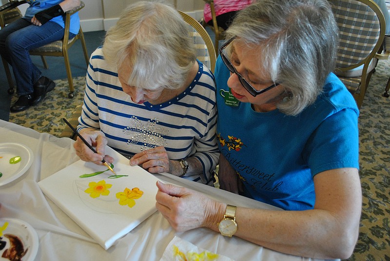 Tina Spillers (right) Bittersweet Garden Club member and organizer of the club's new garden therapy program, watches as her mother and Heisinger Bluffs resident Martine Pelletier paint leaves on her flower painting during the "Art in Bloom" session on April 8, 2019. 