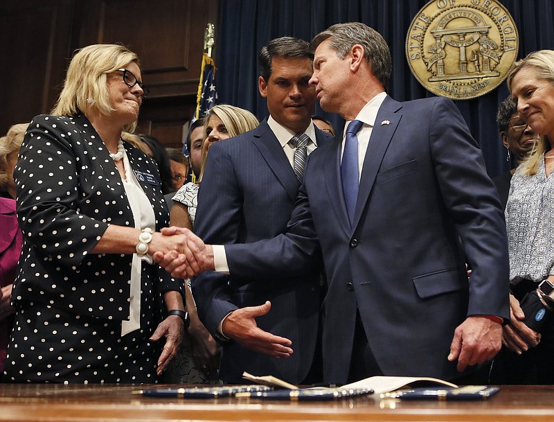 Georgia’s Republican Gov. Brian Kemp, right, shakes hands with state Sen. Renee Unterman, R-Buford, after signing legislation, Tuesday, May 7, 2019, in Atlanta, banning abortions once a fetal heartbeat can be detected, which can be as early as six weeks before many women know they’re pregnant. Kemp said he was signing the bill “to ensure that all Georgians have the opportunity to live, grow, learn and prosper in our great state.” (Bob Andres/Atlanta Journal-Constitution via AP)