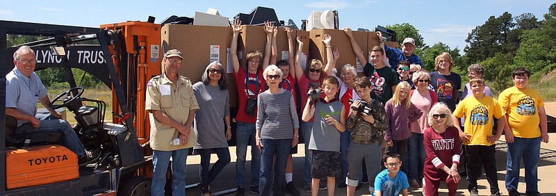 At about the middle of the five-hour E-Waste collection day, volunteers paused for a group photo. The adults jumped right in the middle of the youth workers, most of whom were volunteers from two local Boy Scout troops. Notice the huge pallets that have been loaded on the flat-bed trailers for hauling to Texarkana.