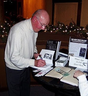 Gunther Skaletz signs a copy of his book, "Life on Both Sides of the Wall," a re-telling of his story of surviving an internment at Auschwitz concentration camp. (Submitted photo)