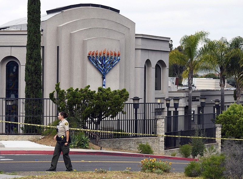 FILE - In this Sunday, April 28, 2019 file photo, a San Diego county sheriff's deputy stands in front of the Poway Chabad Synagogue in Poway, Calif. The gunman who attacked the synagogue last week fired his semi-automatic rifle at Passover worshippers after walking through the front entrance that synagogue leaders identified last year as needing improved security. The synagogue applied for a federal grant to better protect that area. The money, $150,000, was approved in September but only arrived in late March. "Obviously we did not have a chance to start using the funds yet," Rabbi Scimcha Backman told The Associated Press. (AP Photo/Denis Poroy, File)