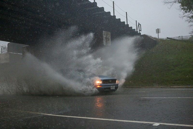 A Ford Mustang drives through the flood zone filled with water from heavy storms on 7th Street going eastbound on Wednesday, May 8, 2019, in Texarkana, Texas.