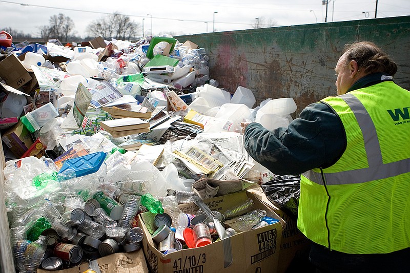 In this February 2010 file photo, Western Waste employee Wendal Hyland throws recyclable materials into a bin at Third and Hazel streets in Texarkana, Ark., on the first day of the Green Texarkana recycling program. The city said Thursday that the program is being discontinued.