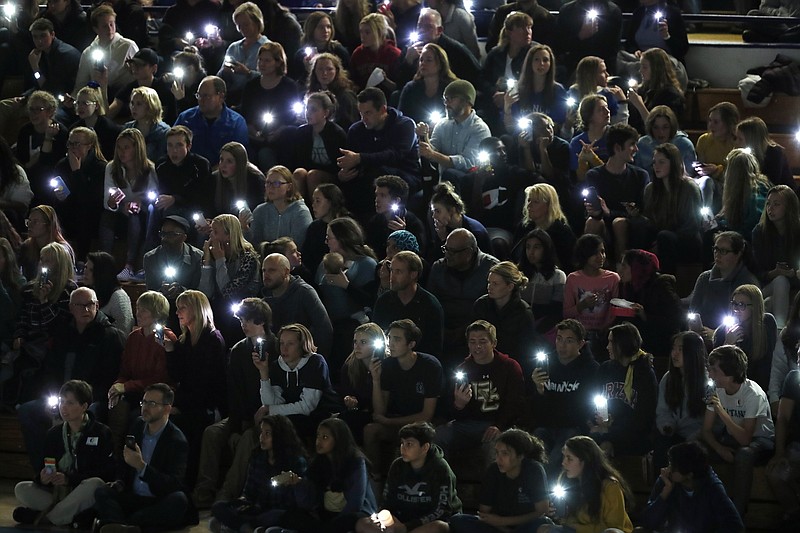 Attendees illuminate their mobile telephones during a community vigil to honor the victims and survivors of yesterday's fatal shooting at the STEM School Highlands Ranch, late Wednesday, May 8, 2019, in Highlands Ranch, Colo. (AP Photo/David Zalubowski)