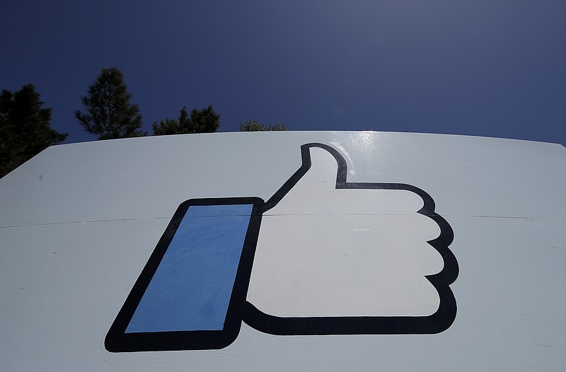 This April 25, 2019, photo shows the thumbs up Like logo on a sign at Facebook headquarters in Menlo Park, Calif. Facebook co-founder Chris Hughes says it’s time to break up the social media behemoth. He says in a New York Times opinion piece that CEO Mark Zuckerberg has allowed a relentless focus on growth that crushed competitors “to sacrifice security and civility for clicks.” (AP Photo/Jeff Chiu)