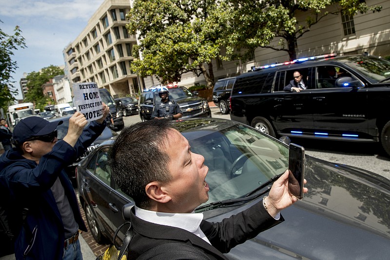 Protesters shout as the motorcade carrying Chinese Vice Premier Liu He and his delegation depart the Office of the United States Trade Representative in Washington, Friday, May 10, 2019, following trade talks between the United States and China. (AP Photo/Andrew Harnik)