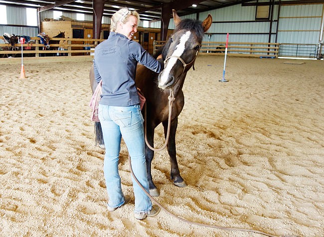 Auxvasse area horse trainer Nikki Tiesing of Forever T Ranch will be taking her project horse, Chasing the Rainbow, to the Extreme Mustang Makeover in June at the Kentucky Horse Park. Taming a wild horse is easier if you know the sweet itchy spots.
