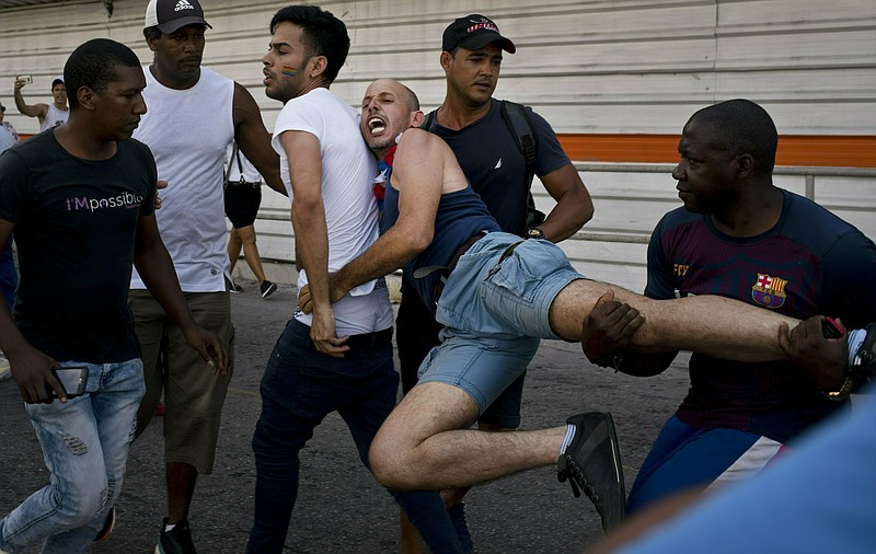 Cuban police detain a gay rights activist taking part in an unauthorized march in Havana, Cuba, Saturday, May 11, 2019.  The march was organized largely using Cuba's new mobile internet, with gay-rights activists and groups of friends calling for a march over Facebook and WhatsApp after the government-run gay rights organization cancelled a Saturday march. (AP Photo/Ramon Espinosa)