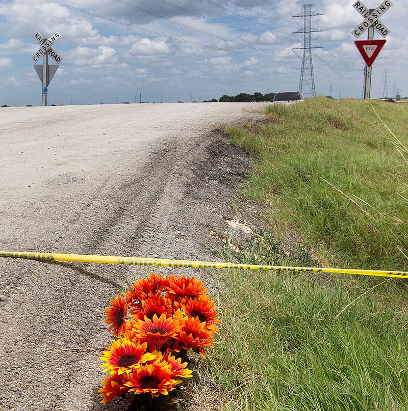 In this July 31, 2016, file photo, flowers sit next to police tape at the site of a hot air balloon crash near Lockhart, Texas. Almost three years after the deadly crash, the Federal Aviation Administration has not passed a new safety regulation that legislators say would fortify supervision of the hot-air balloon industry and help avoid fatal crashes similar to this one that killed 16 people. (Jessalyn Tamez/Austin American-Statesman via AP, File)