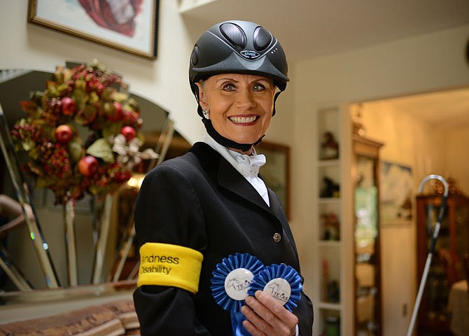 APRIL 2019: Deborah McAlexander holds her first-place ribbons she received for her performance in dressage as she stands in her living room. McAlexander is a JCHS graduate who is the only legally blind active dressage rider in the U.S.