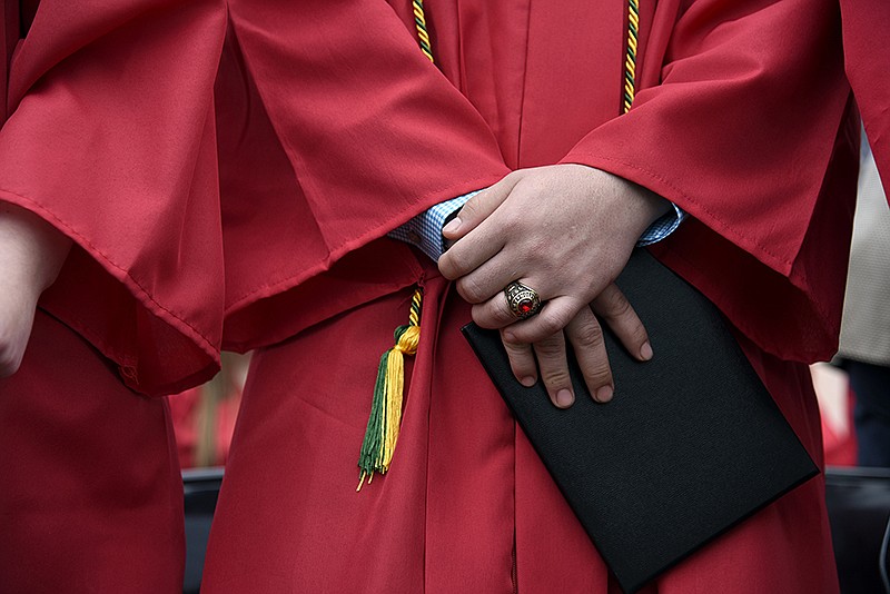 A graduate from Jefferson City High School holds his diploma after walking off stage during the commencement ceremony on Sunday, May 12, 2019, at Adkins Stadium.