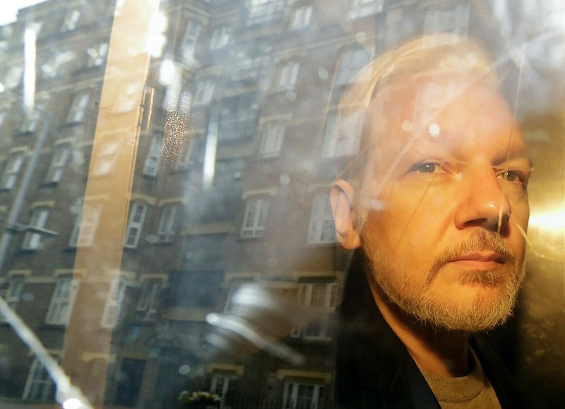 FILE - In this Wednesday May 1, 2019 file photo, buildings are reflected in the window as WikiLeaks founder Julian Assange is taken from court, where he appeared on charges of jumping British bail seven years ago, in London. Swedish prosecutors plan to decide whether they will reopen a rape case against WikiLeaks founder Julian Assange. (AP Photo/Matt Dunham)