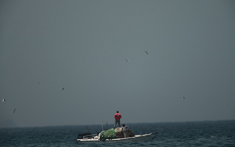 A fishing boat sails in waters off the coast of Fujairah, United Arab Emirates, Monday, May 13, 2019. Saudi Arabia said Monday two of its oil tankers were sabotaged off the coast of the United Arab Emirates near Fujairah in attacks that caused "significant damage" to the vessels, one of them as it was en route to pick up Saudi oil to take to the United States. (AP Photo/Jon Gambrell)