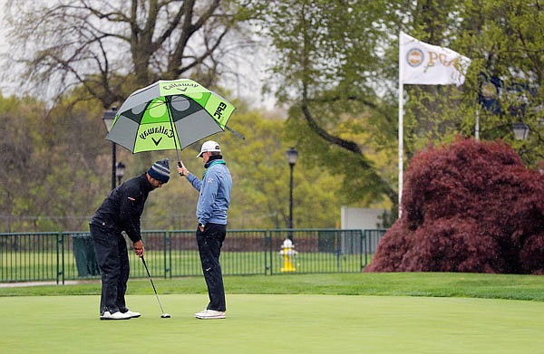 An unidentified player practices on the putting green as a light rain falls Monday during a practice day for the PGA Championship at Bethpage Black in Farmingdale, N.Y. 