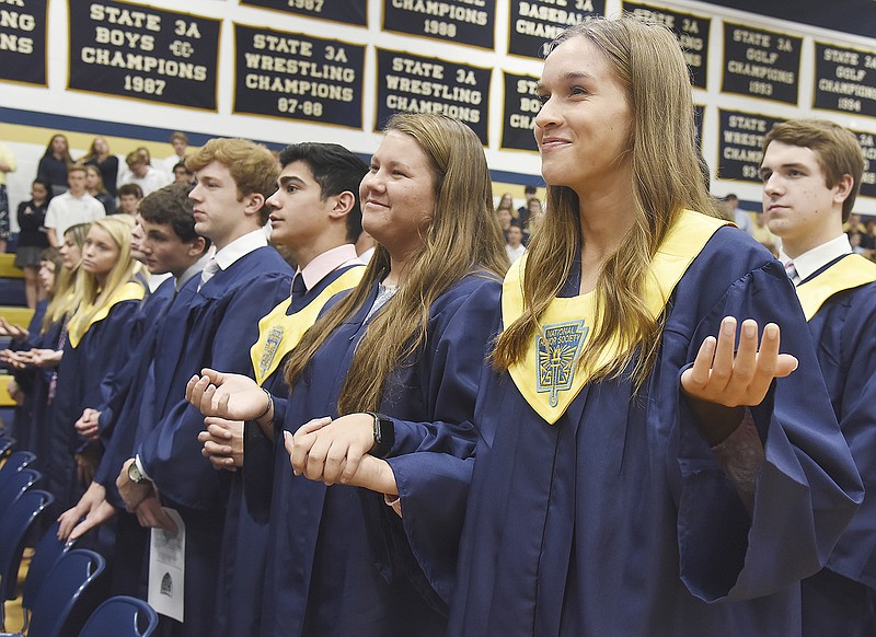 Ellie Rockers, right, and Kenadi Roark hold out their hands Monday during the "Lord's Prayer" as Helias Catholic High School celebrated baccalaureate with a mass in Rackers Fieldhouse. Rockers also received the Father Helias Award which is presented to a senior boy and girl, selected by the faculty, for their outstanding contribution to Helias during their four years of attendance.