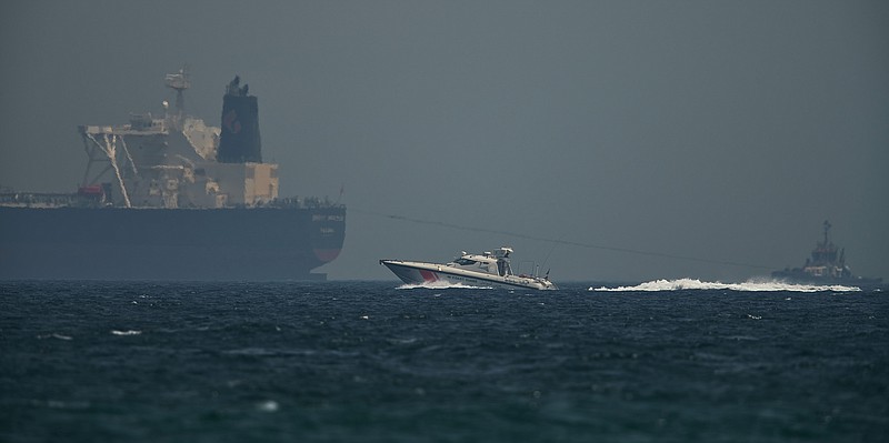 An Emirati coast guard vessel passes an oil tanker off the coast of Fujairah, United Arab Emirates, Monday, May 13, 2019. Saudi Arabia said Monday two of its oil tankers were sabotaged off the coast of the United Arab Emirates near Fujairah in attacks that caused "significant damage" to the vessels, one of them as it was en route to pick up Saudi oil to take to the United States. (AP Photo/Jon Gambrell)