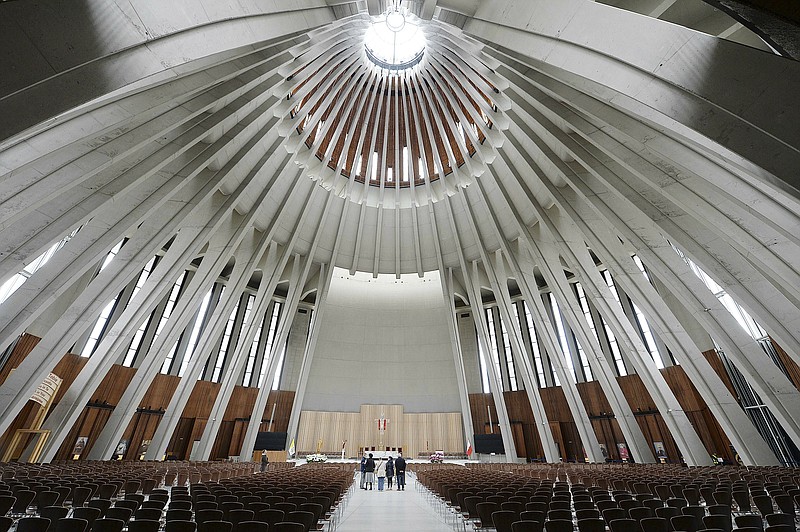 People stand in the Temple of Divine Providence, a major church in the Polish capital, on Monday May 13, 2019. A new documentary about pedophile priests has deeply shaken Poland, one of Europe's most Roman Catholic societies, eliciting an apology from the church hierarchy and prompting one priest to leave the clergy.(AP Photo/Czarek Sokolowski)